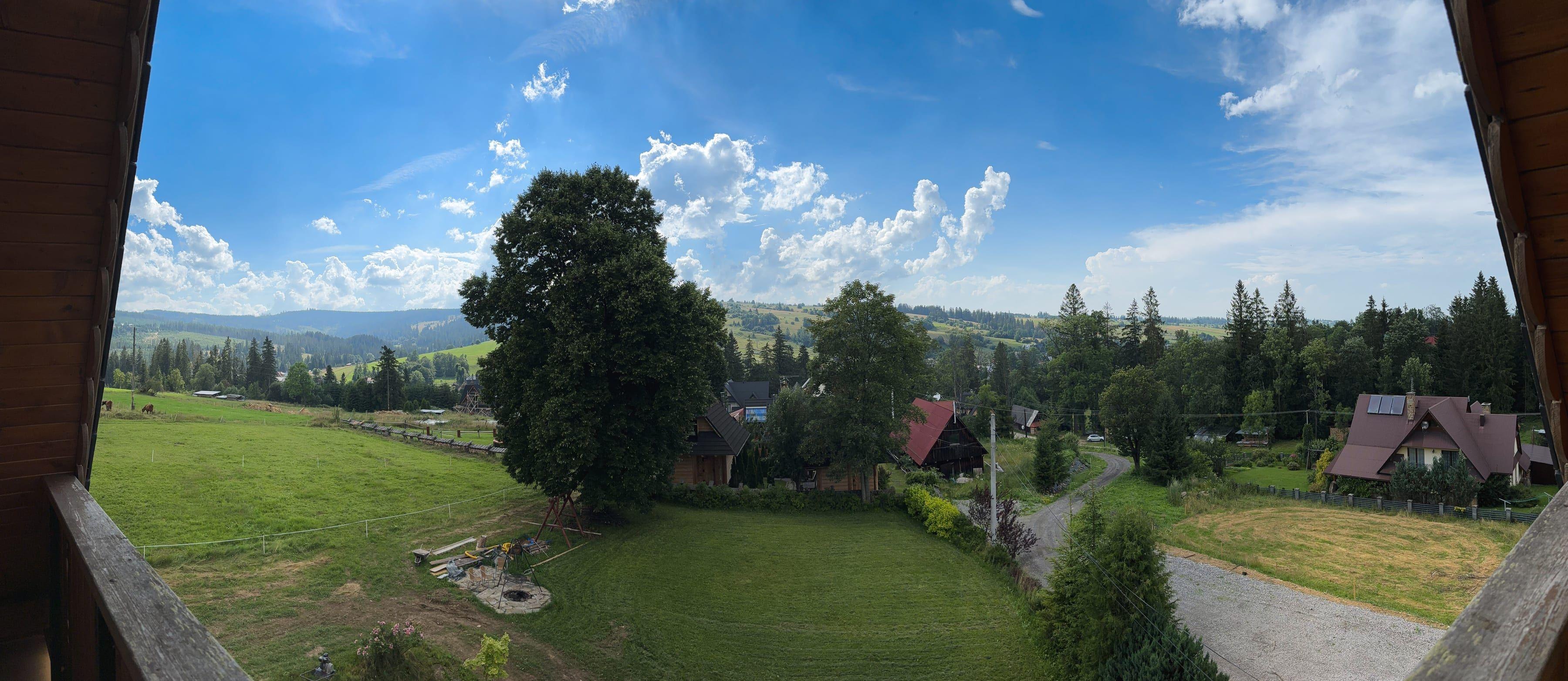 Panoramiczny widok z balkonu na łąki, lasy i wzgórza Dzianisza